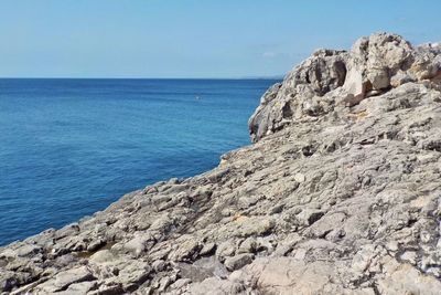 Rock formation on beach against sky