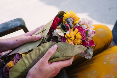 Close-up of hand holding yellow flower