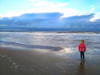 Rear view of child standing on beach