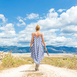 Rear view of woman with umbrella standing on land