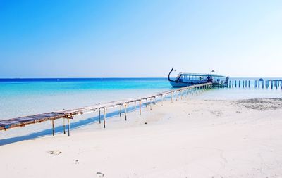 Scenic view of beach against clear blue sky