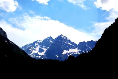 Scenic view of snowcapped mountains against cloudy sky
