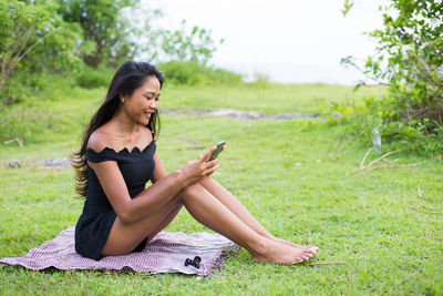 Young woman using mobile phone in park