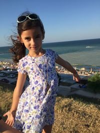 Girl standing on hill against sky