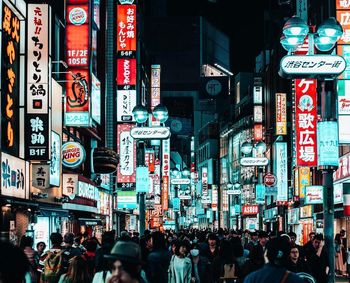 People walking on illuminated street at night