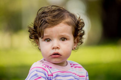 Close-up portrait of cute baby girl sitting at park