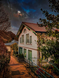 Houses by buildings in town against sky