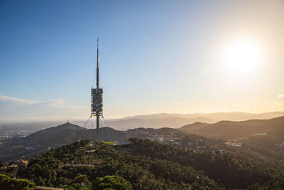 Communications tower against sky during sunset