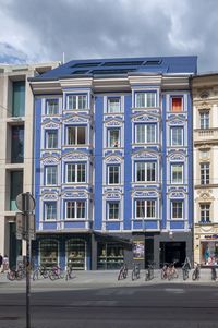 Building by street against sky in city