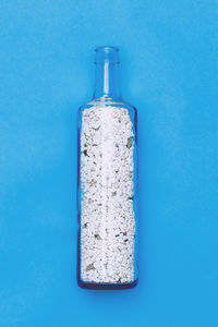 Close-up of glass bottle against blue background