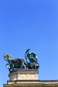 Low angle view of statue against blue sky