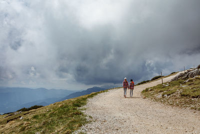 Women walking on mountains against sky