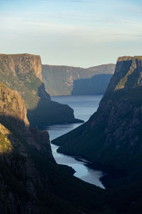 Scenic view of sea and mountains against sky in gros morne national park, newfoundland, canada