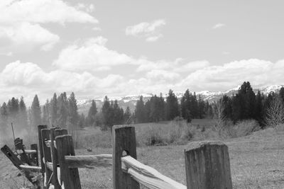 Wooden fence on field against sky