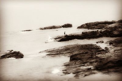 Rocks on beach against clear sky