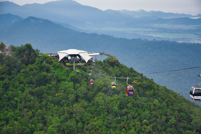 Overhead cable car on mountains against sky