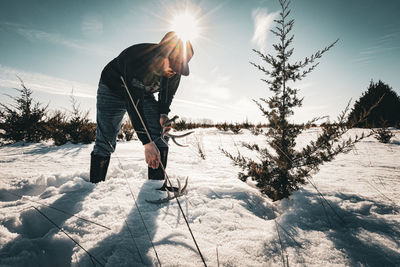 Low section of man skiing on snow covered field