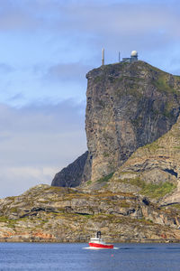 Fishing boat on the sea at high mountain peak with a radar station