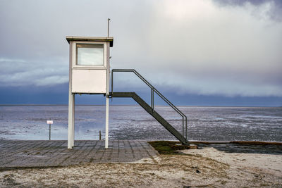 Lifeguard hut on beach against sky