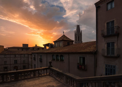 Buildings in town against sky at sunset