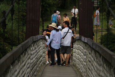 Rear view of couple walking on footbridge