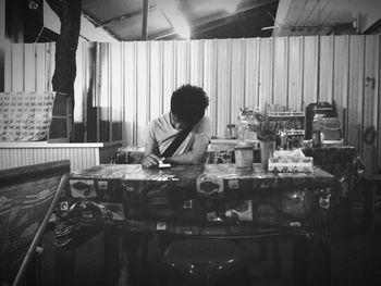 Full length of boy sitting on table at home