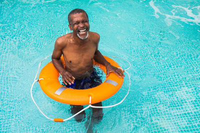 Portrait of shirtless man swimming in pool