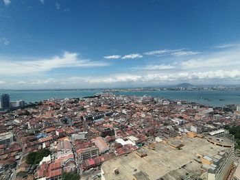 High angle view of townscape by sea against sky