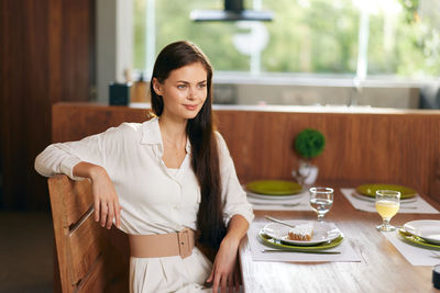 Portrait of young woman sitting on table