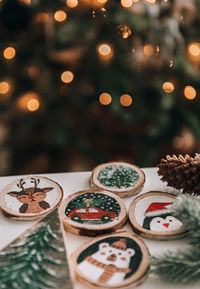 Diy wooden christmas ornaments on table in front of christmas tree