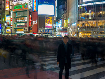 Man walking on illuminated street at night