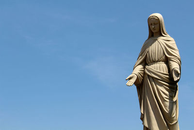 Low angle view of statue against blue sky