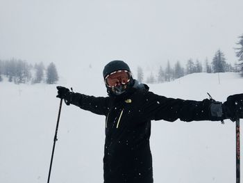 Man with arms outstretched on snow covered landscape