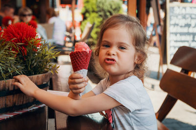 Portrait of cute girl making a face while holding ice cream