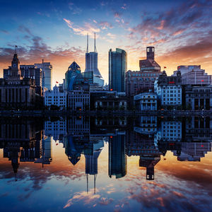 Digital composite image of buildings against cloudy sky