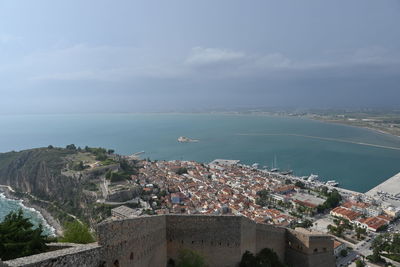 High angle view of townscape by sea against sky