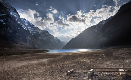 Scenic view of lake by mountains against sky