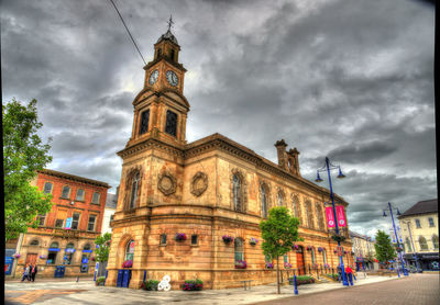 View of buildings and street against cloudy sky