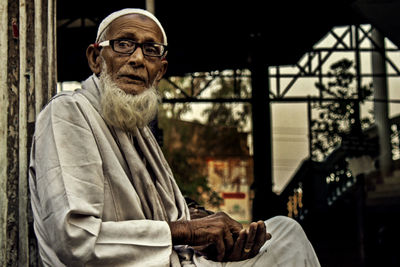 Portrait of man standing against wall