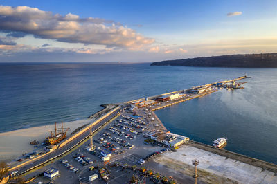 High angle view of city by sea against sky