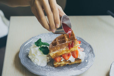 Midsection of person preparing food in plate