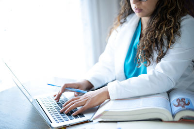 High angle view of woman using laptop on table