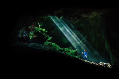 People on rock formation in cave