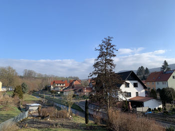 Houses and trees on field against sky, typical german village in ershausen, eichsfeld, thuringia