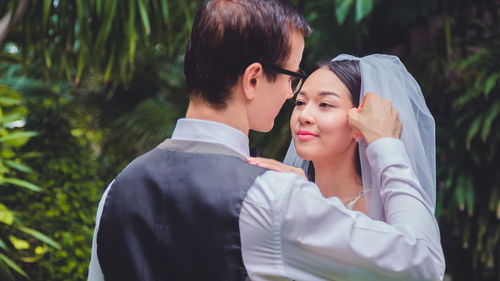 Newlywed couple embracing outdoors