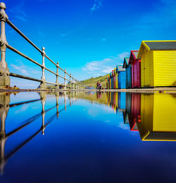 Scenic view of lake and buildings against blue sky