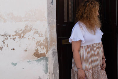 Rear view of woman standing against wall