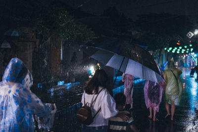 Rear view of people in wet rainy season at night