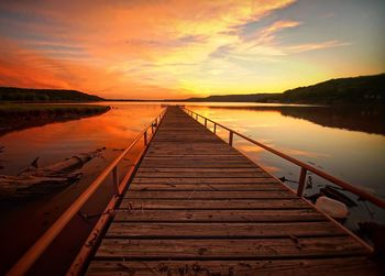 Pier on lake at sunset