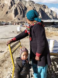 Cute girl by grandmother against mountain